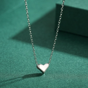 Elegant S925 sterling silver heart pendant necklace on a premium textured dark green background
