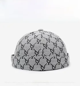 Vista frontale del cappello docker grigio con motivo jacquard geometrico e risvolto arrotolato