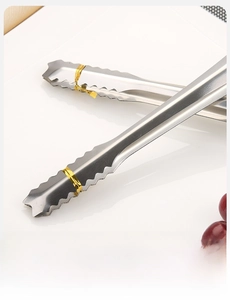 Macro shot of stainless steel ice tongs with serrated teeth and gold tie detail