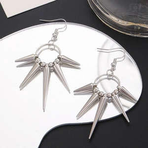 Macro shot of silver spike cone drop earrings with punk gothic style on mirror surface