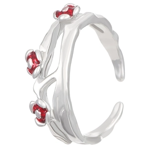 Macro detail of gothic branch ring with red floral accents and adjustable silver band