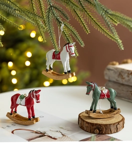 Détail de suspensions chevaux à bascule en résine rouge, blanc et vert pour décor de Noël