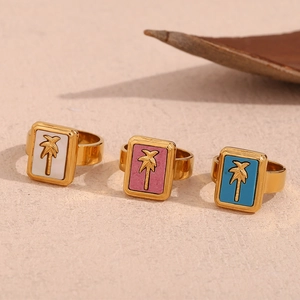 Detailed close-up of gold stainless steel rings with colorful coconut tree square charms