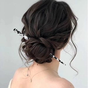 Nahaufnahme eines schwarz-weißen Acetat-Haarstabs mit Wirbelmuster in einem Haarknoten