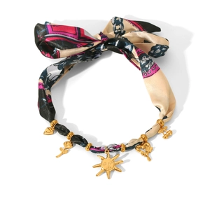 Detail of silk scarf necklace with golden sun face, rose and heart charms on white background