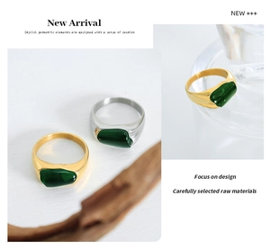 Detailed macro view of irregular gold and silver rings featuring deep green gemstone inlay