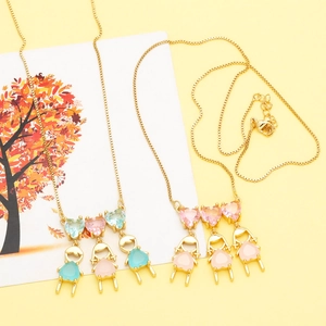 Close-up of gold necklaces with zircon heart pendants and colorful girl charms