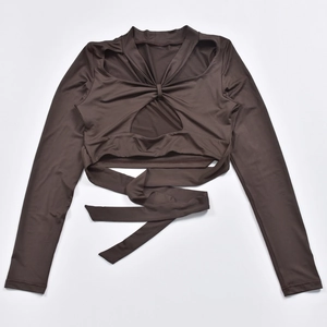 Detail eines dunkelbraunen Langarm-Crop-Tops mit Cut-out-Brust und Taillen-Schnürung