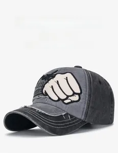 Detail der grauen verwaschenen Denim-Baseballkappe mit Faust-Patch und Fransenrand