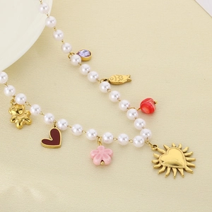 Close-up of pearl necklace featuring colorful heart, fish and flower charms on a beige surface