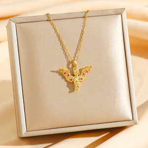 Elegant Cupid angel necklace in gold finish with red crystal accents on a silk display