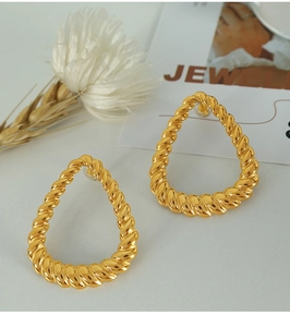 Macro detail of golden twist textured drop earrings made of durable titanium steel