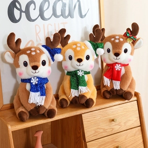 Three cute Christmas reindeer plush toys with festive hats and knit scarves on a shelf