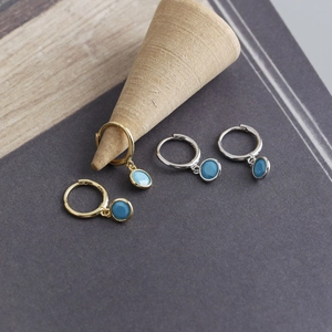 Macro shot of S925 sterling silver hoop earrings with blue faceted zircon stones