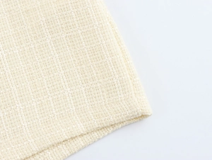 Détail de la texture du tissu en tweed blanc crème montrant les couches et la texture épaisse