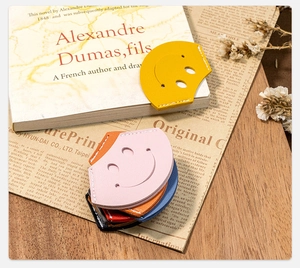 Detailed close-up of colorful PU leather smiley face corner bookmarks with stitching