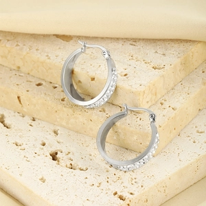 Silver double-row crystal stainless steel hoop earrings on beige stone display