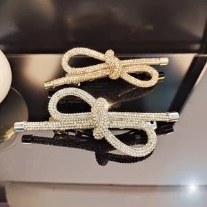 Detailed view of elegant gold and silver bow hair clips with sparkling rhinestones