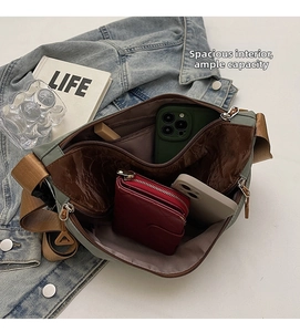 Detail of grey-green crossbody bag with large capacity, interior layers and brown strap