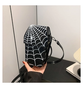 Detail of black spider pattern and glossy PU leather texture on the crossbody bag