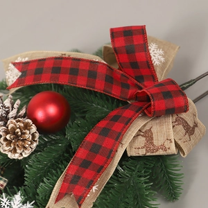 Décoration de Noël avec rubans à carreaux, boules rouges et pommes de pin sur sapin PE