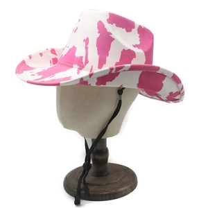 Detailed view of pink and white cow print cowboy hat with adjustable black chin strap