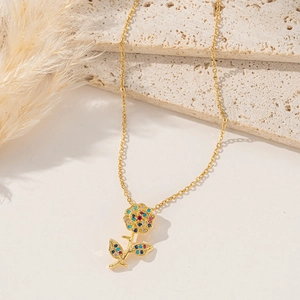 Elegant gold flower necklace with colorful cubic zirconia on a stone texture background