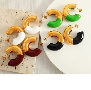 Detail view of four pairs of C-shaped gold hoop earrings with colorful enamel finishes