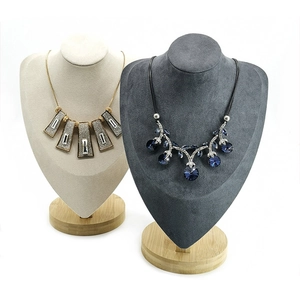 Detail of elegant necklaces on velvet bust displays with solid wooden bases