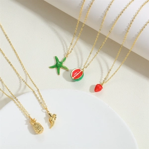 Detail of 14k gold-plated necklaces with colorful fruit and starfish enamel pendants