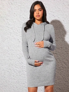 Detail of grey ribbed knit texture on a hooded maternity dress with drawstring