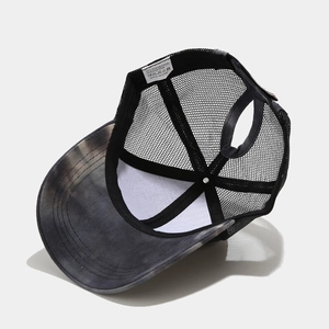 Detail of breathable mesh backing and ponytail hole on tie-dye trucker hat