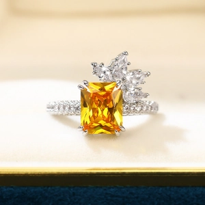 Macro view of emerald-cut yellow gemstone ring with asymmetrical white diamond clusters