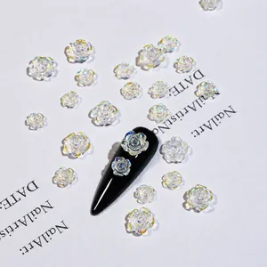 Macro shot of 3D iridescent camellia nail charms with pearlescent finish on dark polish