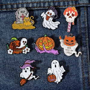 Detailed view of Halloween ghost enamel pins set pinned on blue denim fabric background