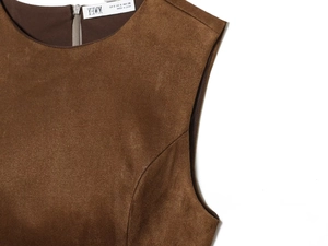 Détail de robe courte en daim marron foncé avec col rond et fermeture éclair au dos