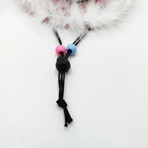 Detail of pet cowboy hat with white feather trim and adjustable cord with beads