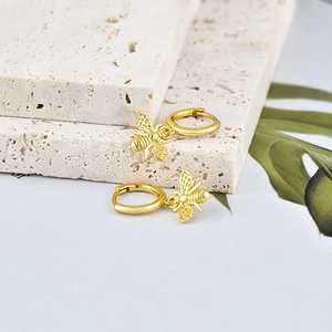 Elegant gold S925 sterling silver bee hoop earrings with hollow wing details on white marble