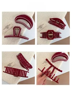 Macro details of deep red shark hair clips with cream edging and gold metal spring