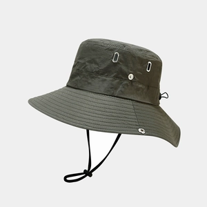 Dettaglio cappello da sole verde oliva con trama in nylon ripstop e fori metallici
