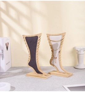 Detail of wooden jewelry display stand with velvet surface and necklace hooks
