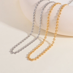 Detailed shot of hollow heart links on polished gold and silver woven necklaces