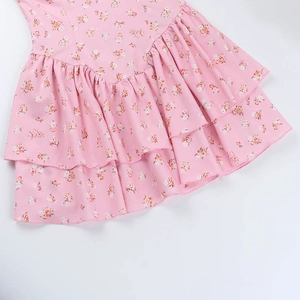 Gros plan d'une robe fleurie rose avec ourlet à volants multicouches et tissu imprimé
