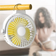 Detail of portable mini fan with yellow blades hanging on a yellow horizontal bar