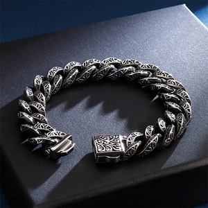 Detail of vintage embossed pattern on mens heavy stainless steel Cuban link bracelet