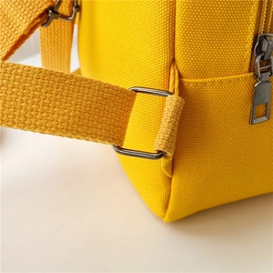 Detailed close-up of yellow canvas kids backpack with durable strap and silver metal buckle