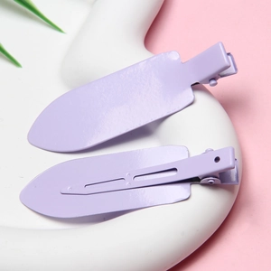 Close-up of purple matte finish metal hair clips on a white tray for hair styling