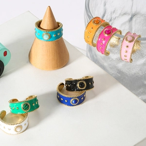 Detail of colorful enamel wide rings featuring natural stones and gold bead accents