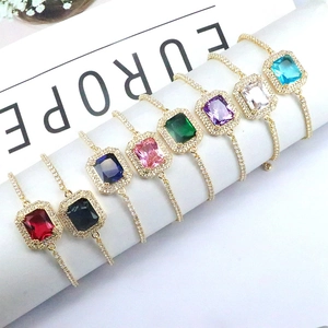 Macro shot of rectangular colorful zircons and golden adjustable chains displayed on a stand