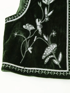 Macro detail of sequin floral embroidery on luxury dark green velvet vest fabric